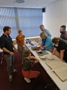 Eine Gruppe des Workshops schaut sich eine Sammlung der Staats- und Universitätsbibliothek Hamburg an.