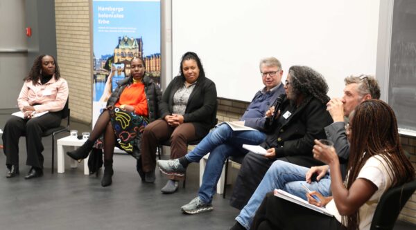 Podiumsdiskussion: „Erinnerungskultur & Geschichtspolitik“ mit Naita Hishoono, Beatrace Oola, Doreen Denstädt, Moderator Jürgen Zimmerer, Wilma Nyari, Oliver von Wrochem und Sonia Octavio (v.l.n.r.). Foto: Nils Lehmann/UHH