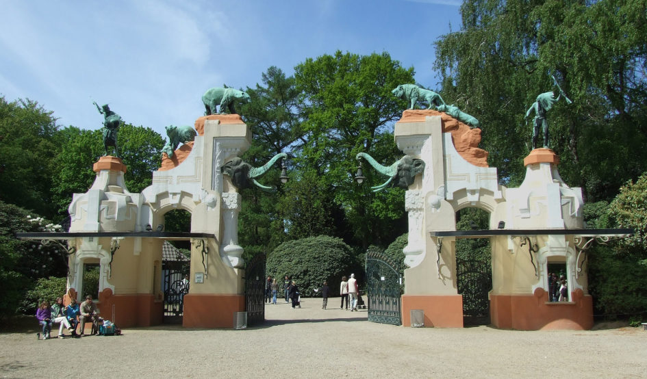 Das Bild zeigt das Portal des ehemaligen Haupteinganges des Tierpark Hagenbeck, Hamburg. Zu sehen sind Tier und und Menschenfiguren auf dem Portal.