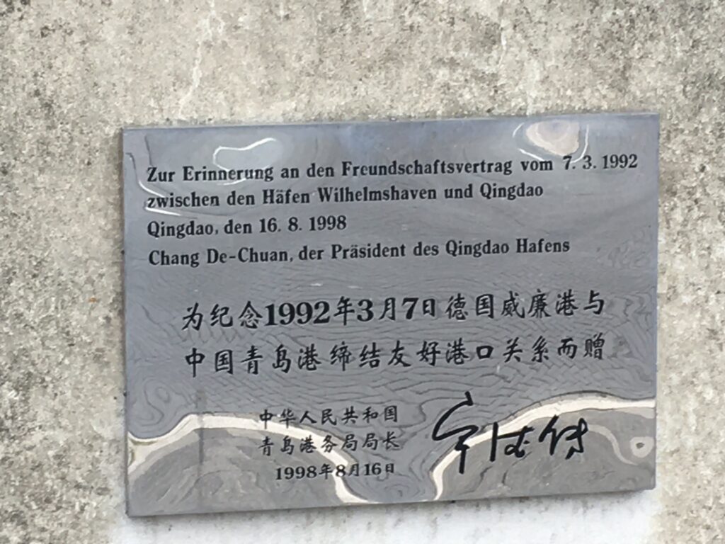 Plakette auf dem Sockel des 1998 gestifteten Adlers von der Stadt Qingdao anlässlich der Städtepartnerschaft mit Wilhelmshaven.