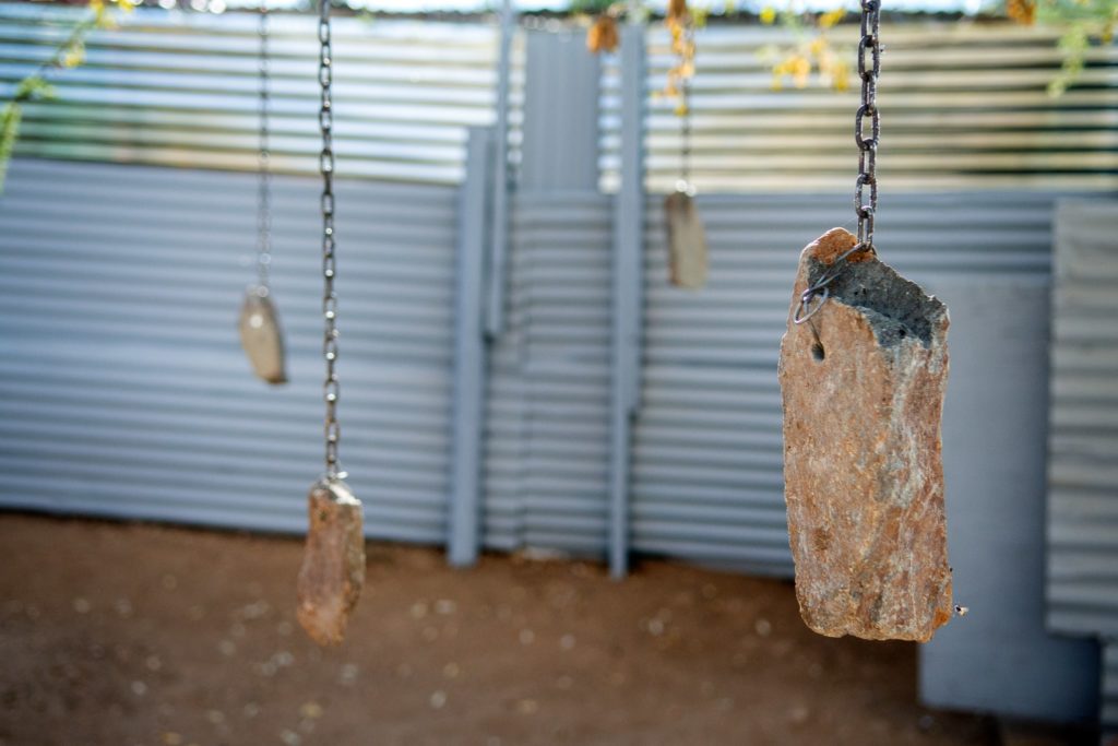 Detail der Installation "pathway to death": drei Steine, die an Ketten hängen