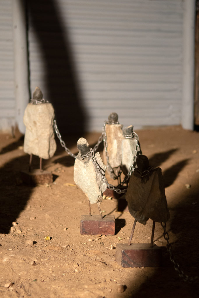 Detail der Installation "pathway to death": Skulpturen, die durch Ketten verbunden sind